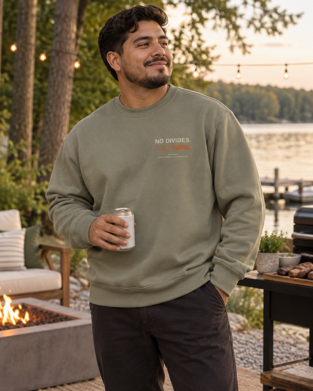 Latino man wearing the eucalyptus Pollyanna Men’s Heavy Crew beside a lake