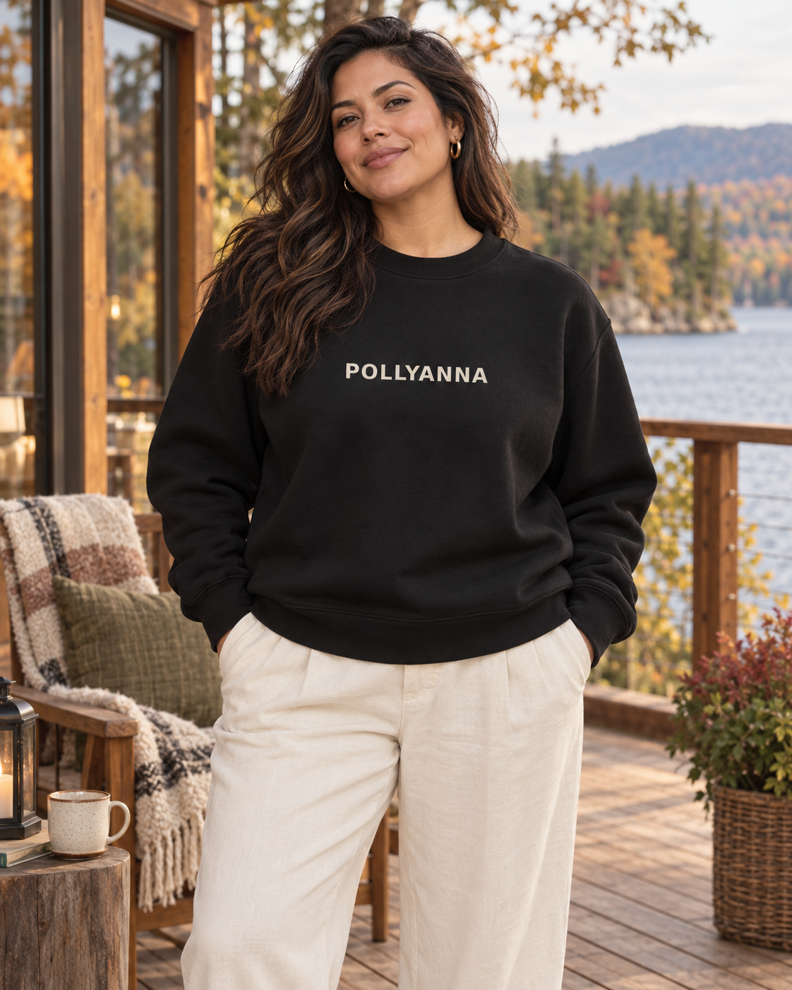 Latina woman wearing the black Pollyanna Women’s Heavy Crew at a lakeside lodge